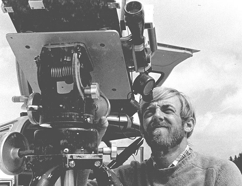 A man with a beard looks through a large piece of equipment