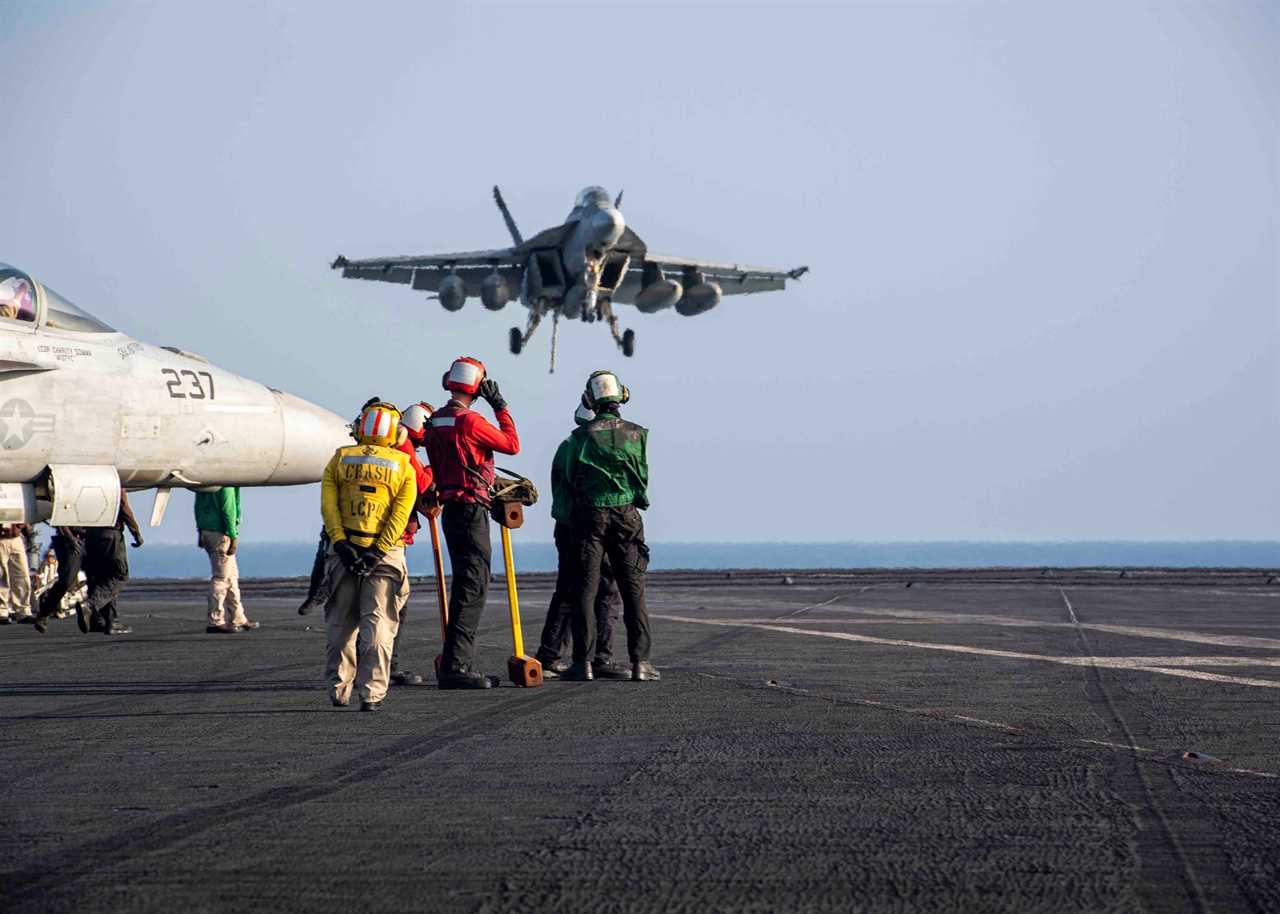 Sailors observe as an F/A-18E Super Hornet lands on the flight deck aboard the Nimitz-class aircraft carrier USS Dwight D. Eisenhower in the Red Sea on March 12.