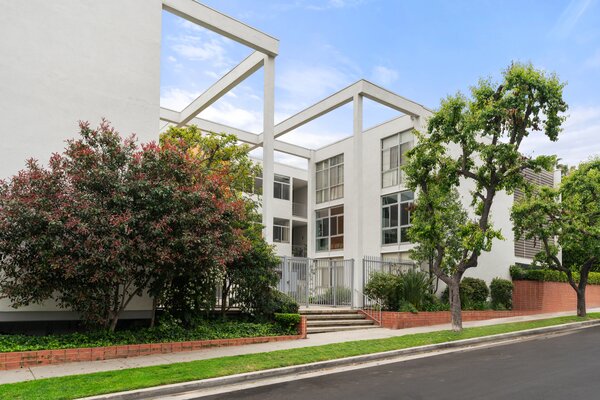 The crisp white building offers a gated entrance and sweeping views of the Hollywood Hills. Resident parking is also included.