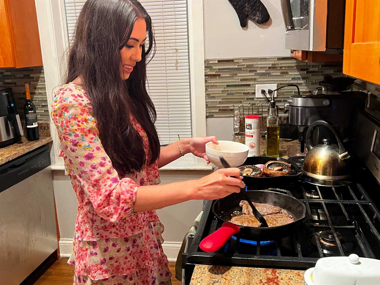 Lara brushes the glaze on the steak while it's cooking on the stove.