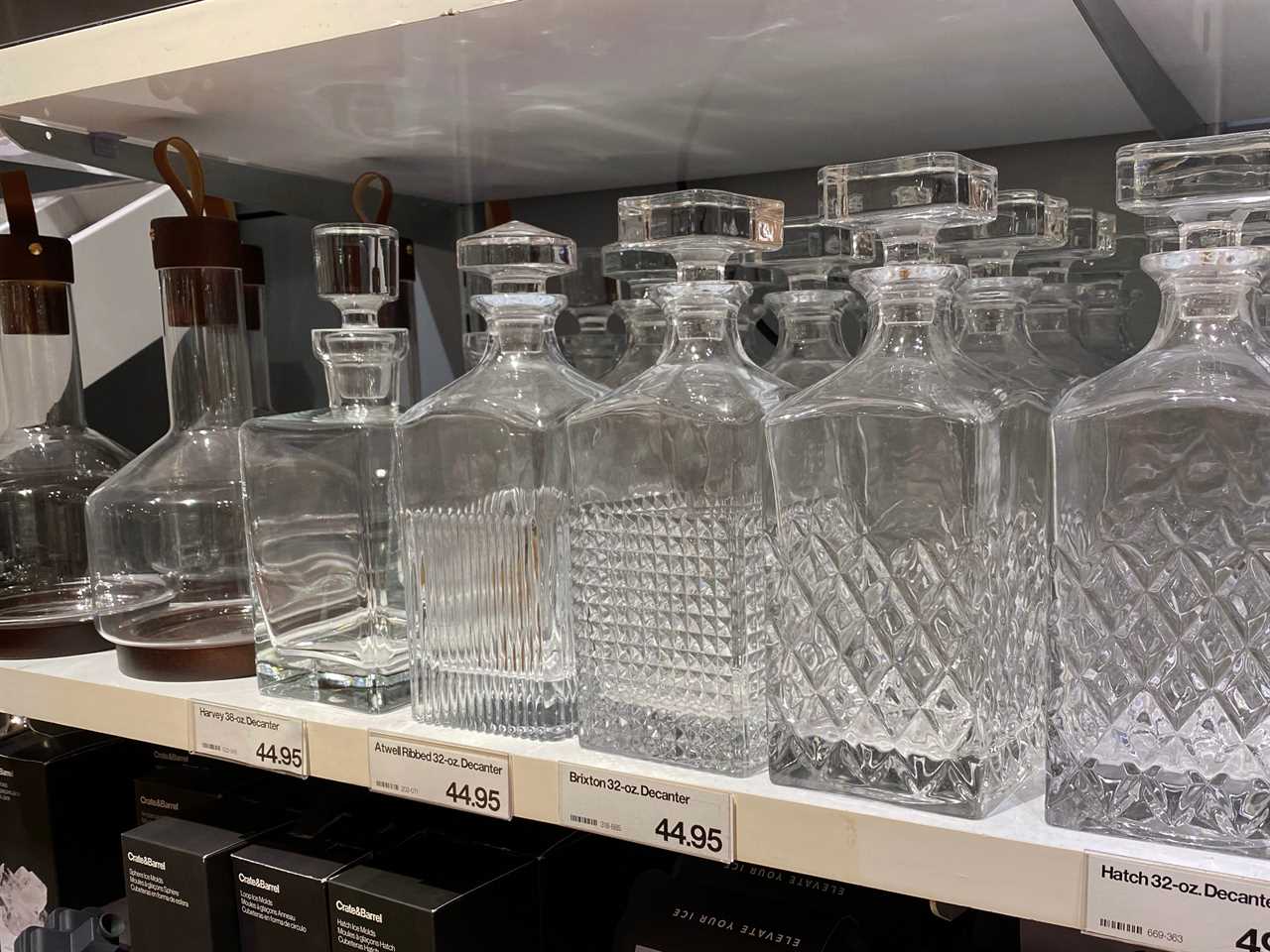 Several clear containers with details to make them look like crystal on shelves at Crate and Barrel