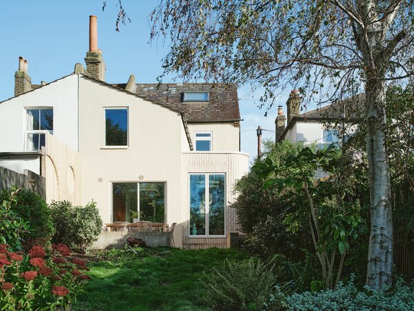 The home now features an elegant, brick side extension with a rounded form that elevates the view of the home from the garden. 