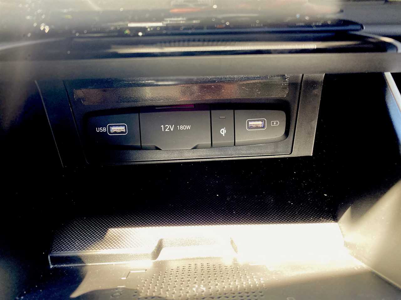 The 2024 Hyundai Tucson Hybrid SUV's front dash-mounted USB, 12V, and wireless chargers.