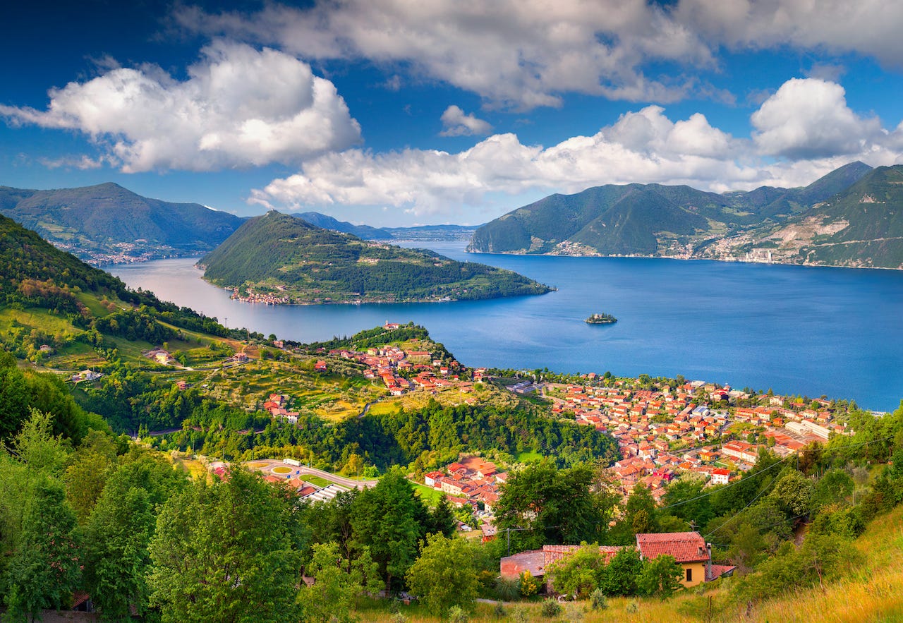 A view of Lago Iseo and the island of Monte Isola in the center on a sunny day.