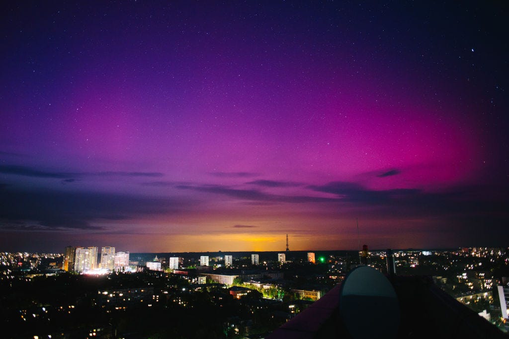 The moon is being illuminated by light reflected from the Earth and is surrounded by the northern lights, in Kharkiv, Ukraine, on May 10, 2024. (Photo by Pavlo Pakhomenko/NurPhoto via Getty Images)