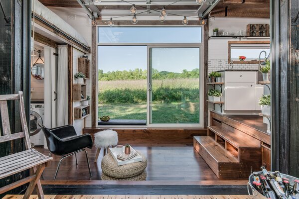 The central living space can be converted into a dining room by pulling out the steps leading up the kitchen—and with it, a fold-up table and two benches that seat eight people.