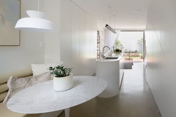 Sticking to a simple linear staircase allowed architect Justine Money to pack storage into the narrow space and create a dining nook.