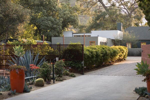 Low-maintenance landscaping borders the gated entry, while verdant greenery helps conceal the 4,533-square-foot home from street-view.