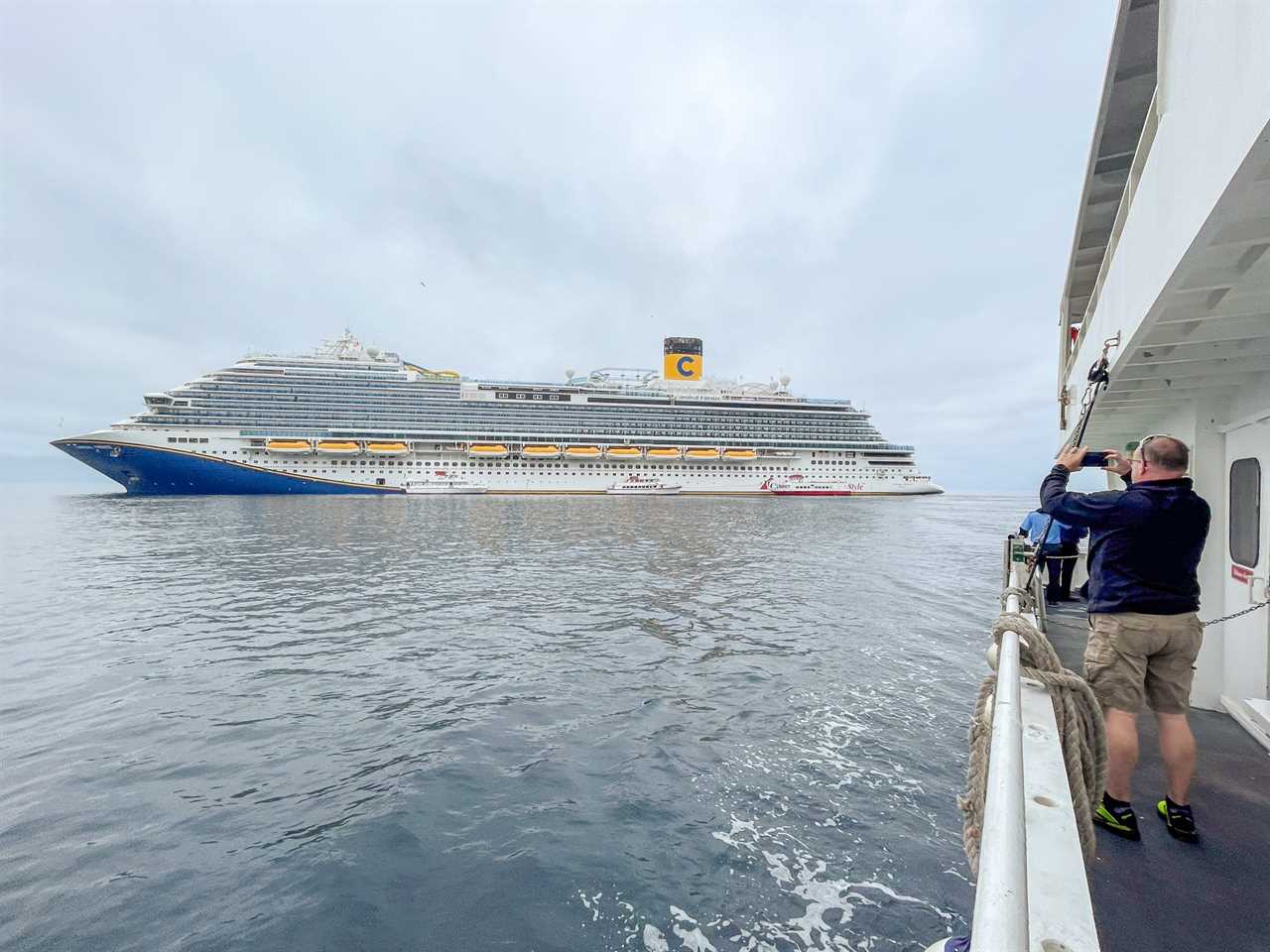 person taking picture of Carnival Firenze cruise ship