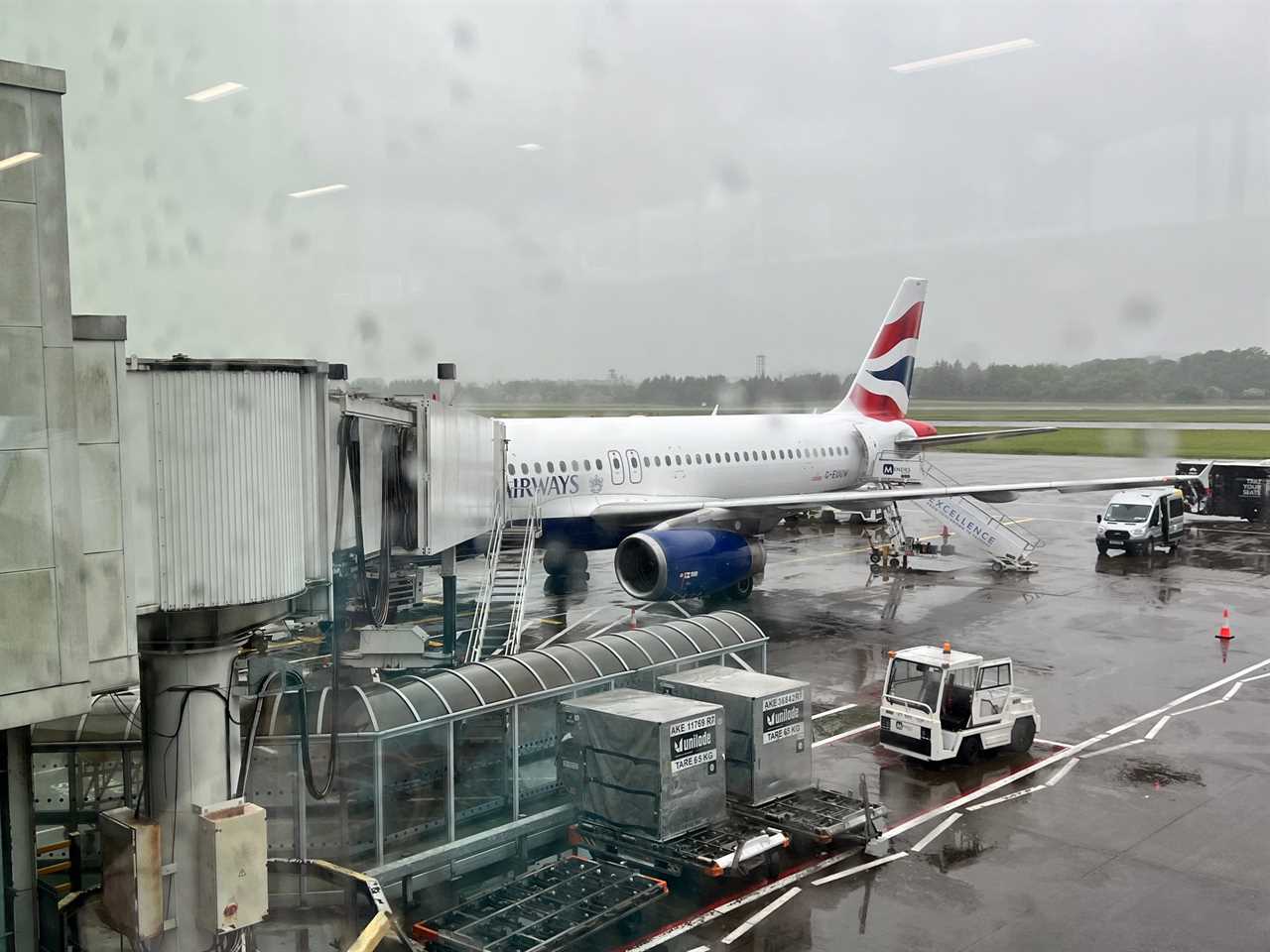 A British Airways Airbus A320 at the gate at Edinburgh Airport on a rainy day.