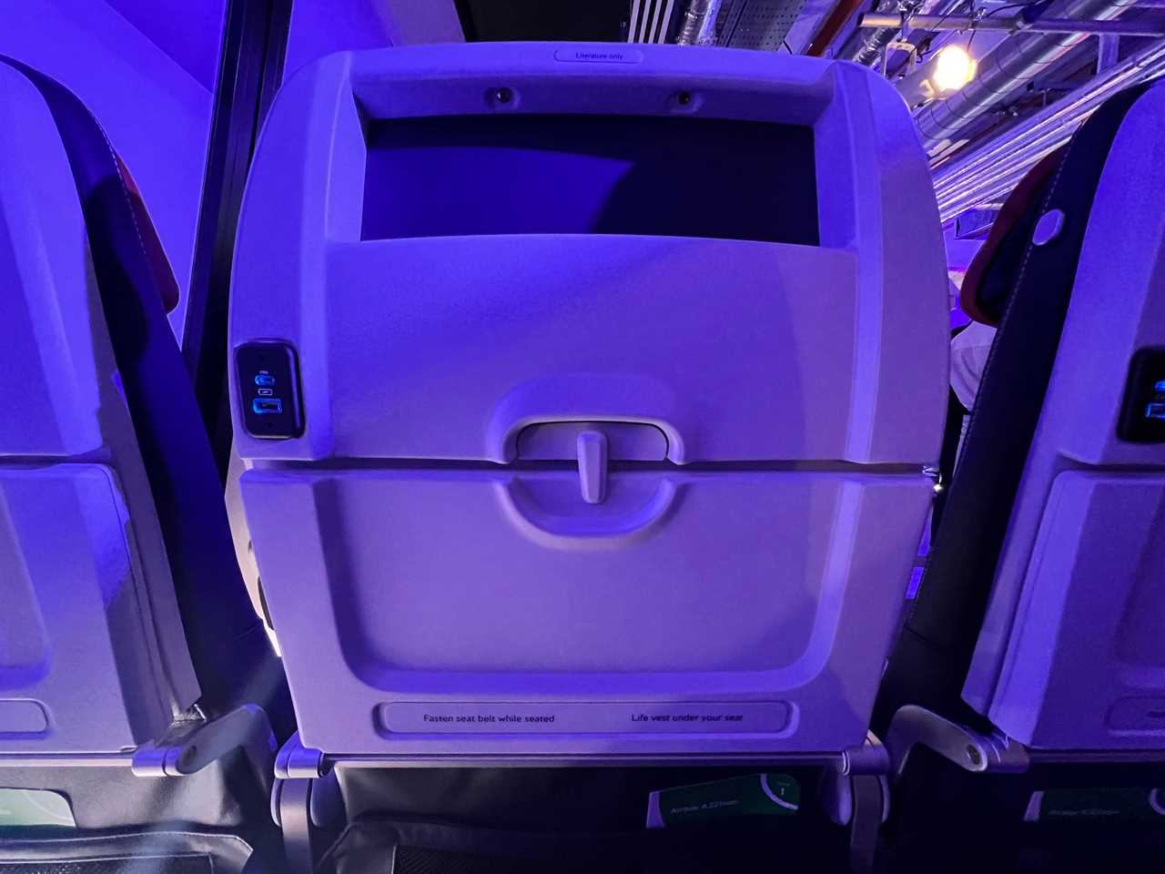 The seatback on British Airways' new short-haul design, with tray table folded up and two USB ports visible.