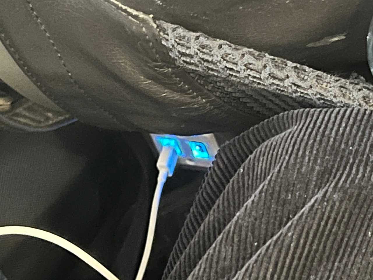 Two USB sockets with one in use viewed on a British Airways Airbus A320.