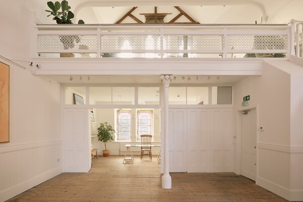 In the gallery portion, a mezzanine overlooking the ground floor provides storage and further desk space.