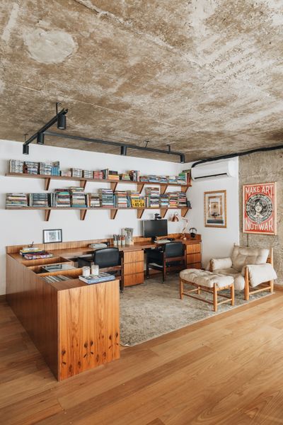 The apartment in the heart of São Paulo, Brazil, that FJ55 Arquitetos renovated for Carolina Quevedo and Marcus Watari was once a podcast studio. The space’s wide-open kitchen, dining, and living area is outfitted with tauari wood floors and features raw concrete ceilings, beams, and pillars.