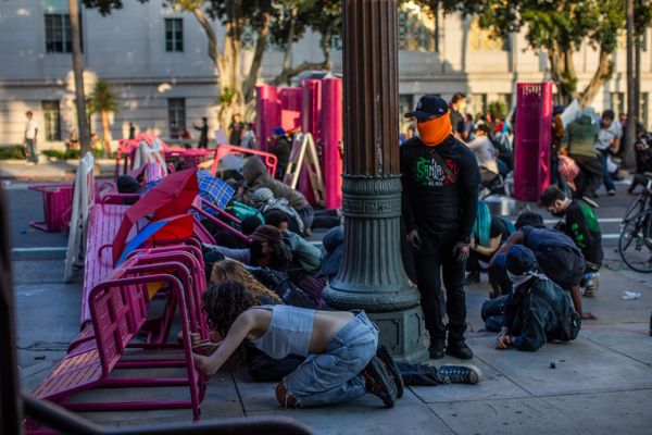 Protesters in Los Angeles seek shelter from police behind a makeshift barricade in front of City Hall.