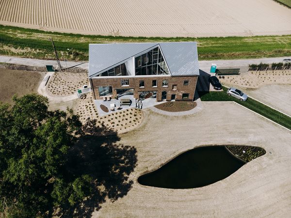 OYO Architects carved a massive slice out of the roof to bring in light, views, and greenery, while landscape designer Denis Dujardin added an unusual garden with a rainwater recycling pond.