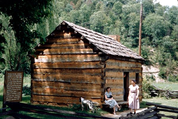Tourists gather outside a log cabin at the birthplace of United States President Abraham Lincoln, Kentucky, United States, 1955.