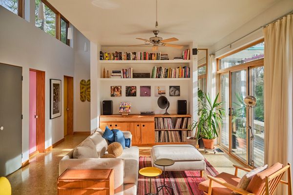 The living room is illuminated by clerestory windows and sliding glass doors that open to a deck.