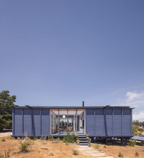 Only the north-facing side of the house, seen here, has sections with opaque timber walls to protect the primary suite (and a mud room) from the bright southern hemisphere rays. Behind the glass doors is an interior patio outfitted with a woodburning parrilla.