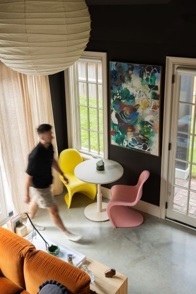 A Noguchi pendant hangs over the main living area, where a set of vintage Panton chairs flank a West Elm cafe table. Creamy white trim balances the industrial look of the polished concrete floors. The painting over the table is by one of Ben's friends, artist Haylee Moree.