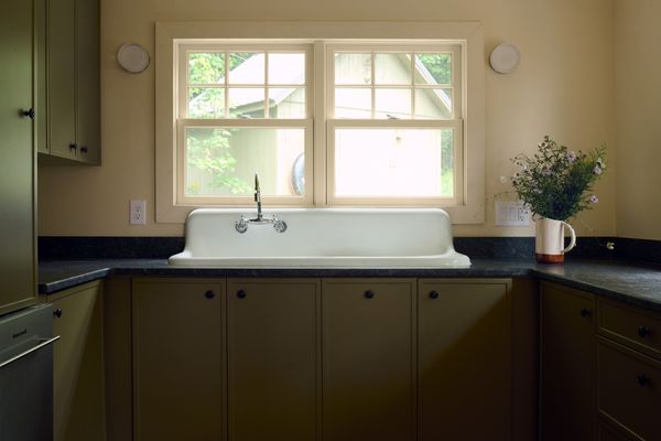 A vintage apron front sink now anchors the kitchen, with new cabinetry, drawer pulls by Linnea, and honed granite countertops.