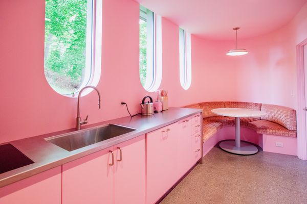 Mike’s gentle sense of humor permeates the space, along with his penchant for midcentury modernism. He wanted a pink kitchen, so his designers, architect Brian Mac and interior design-er Brooke Michelsen, gave him one accented by a vintage pendant with a custom banquette and cabinetry filled with pink appliances and cookware. Birdseye Woodshop made the cabinetry and banquette. The cushions are from Designers Guild, and the ceiling pendant is from Door 15. The Eos Neo pull-down faucet is from Franke.