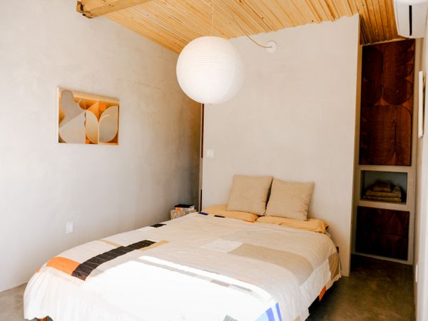The pendant in the bedroom is by Isamu Noguchi, and the duvet was made by a friend of Aa-ron’s, artist Ellen Rutt. Another painting by Aaron hangs beside the bed.