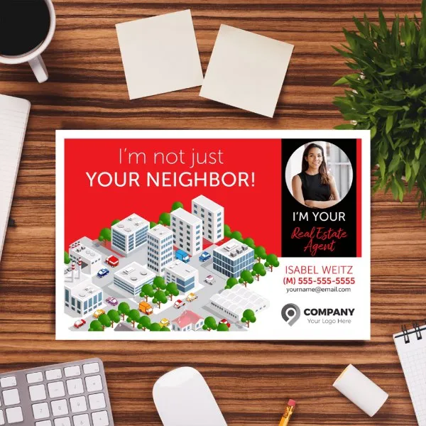 Background of a desk with office supplies and a post card marketing an agent in the middle.