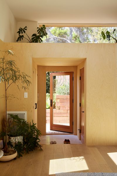 The entrance is surrounded by maple plywood. "We created this wood box that felt compressed within a space that has eight-foot ceilings,