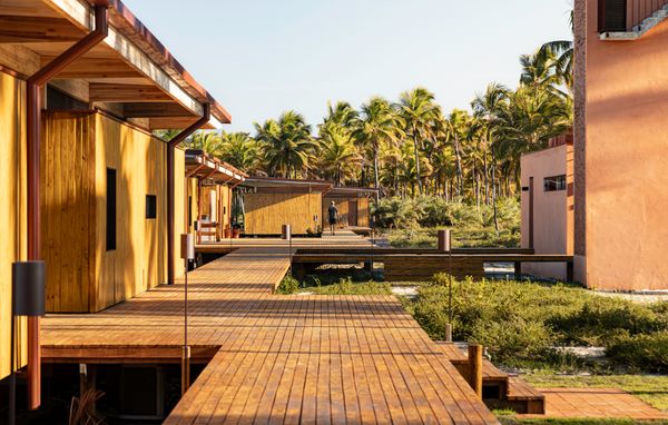 A suspended wooden deck pathway links the six modules.