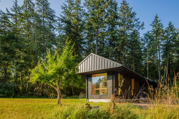 Ets Architecture designed a cabin on Lopez Island that is split into three separate structures connected via breezeway and a raised boardwalk.