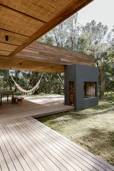 Most homes in the area have woodburning <i>parrillas</i> to make <i>asados</i>, or barbecues. Ochoa designed his own to be open on both sides, which provides extra heat to the patio during colder days. The deck is made of lapacho, and the ceilings are covered in straw.