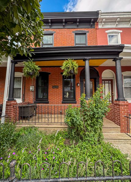 The couple refreshed the paint on the porch, and added a new concrete walkway. Eric refinished the front door, while April installed cat-friendly landscaping.