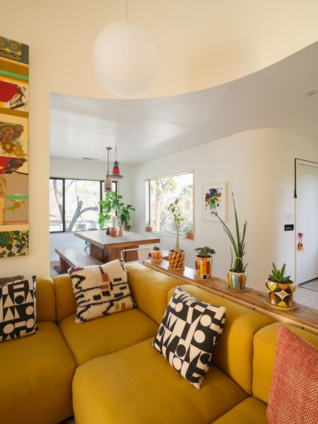Antonio designed the console table using a zebrawood plank that once adorned the fireplace, which was removed during the renovation. In the dining area beyond, pendants by Torbjörn Vejvi hang above the Kayu teak table from Design within Reach.