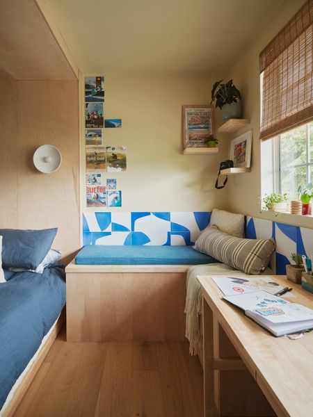 The built-in desk area features Concrete Collaborative's Dazzling Blue tiles running the length of the window, creating a vibrant backdrop that anchors the room's color palette.