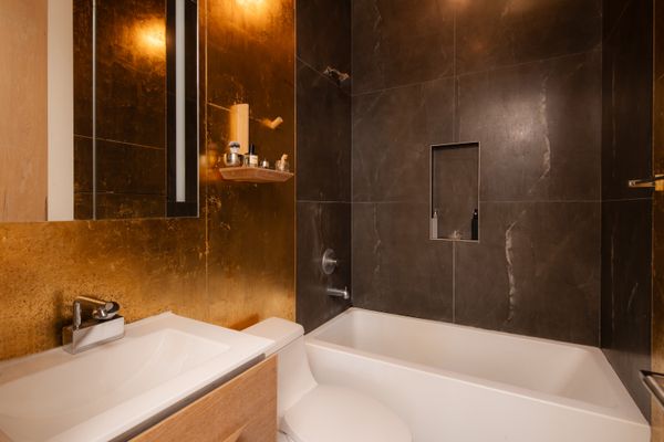 Shkurti’s goal with covering the white walls with gold leaf was to make the material transition to the black shower tile more interesting and less jarring.