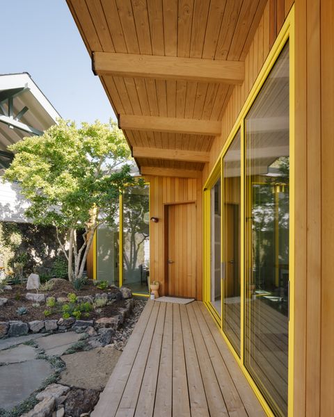 Cedar siding clads the building's garden-facing facade and eaves over the wraparound porch and will turn silver over time.