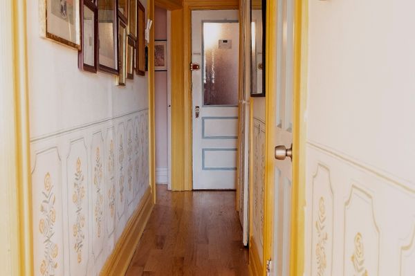 The low mural in interior designer Sydney Moss’s Brooklyn hallway helps split the narrow space in half.