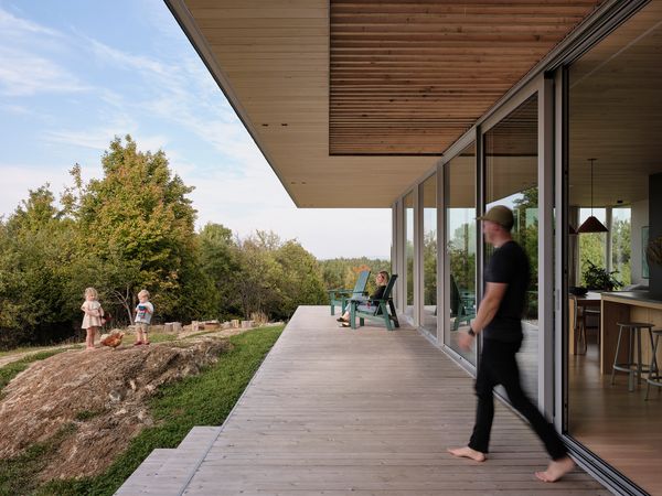 The wooden terrace spans the length of the house, connecting the building directly to the landscape.