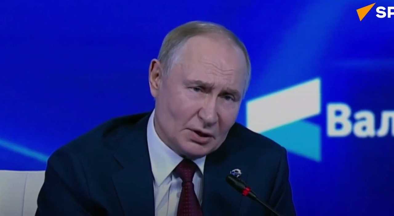 Vladimir Putin speaks at a press conference, addressing key political issues against a blue background with branding elements.