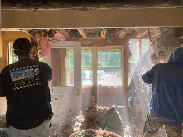 A team rips out its molding insulation in preparation for a retrofit with hemp.