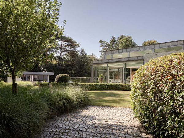 A Contemporary Villa in Belgium Comes Complete With a Landscape Pond and Showroom Garage