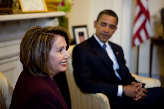 Nancy Pelosi and Barack Obama engaged in conversation in a formal setting, highlighting their roles in American politics.