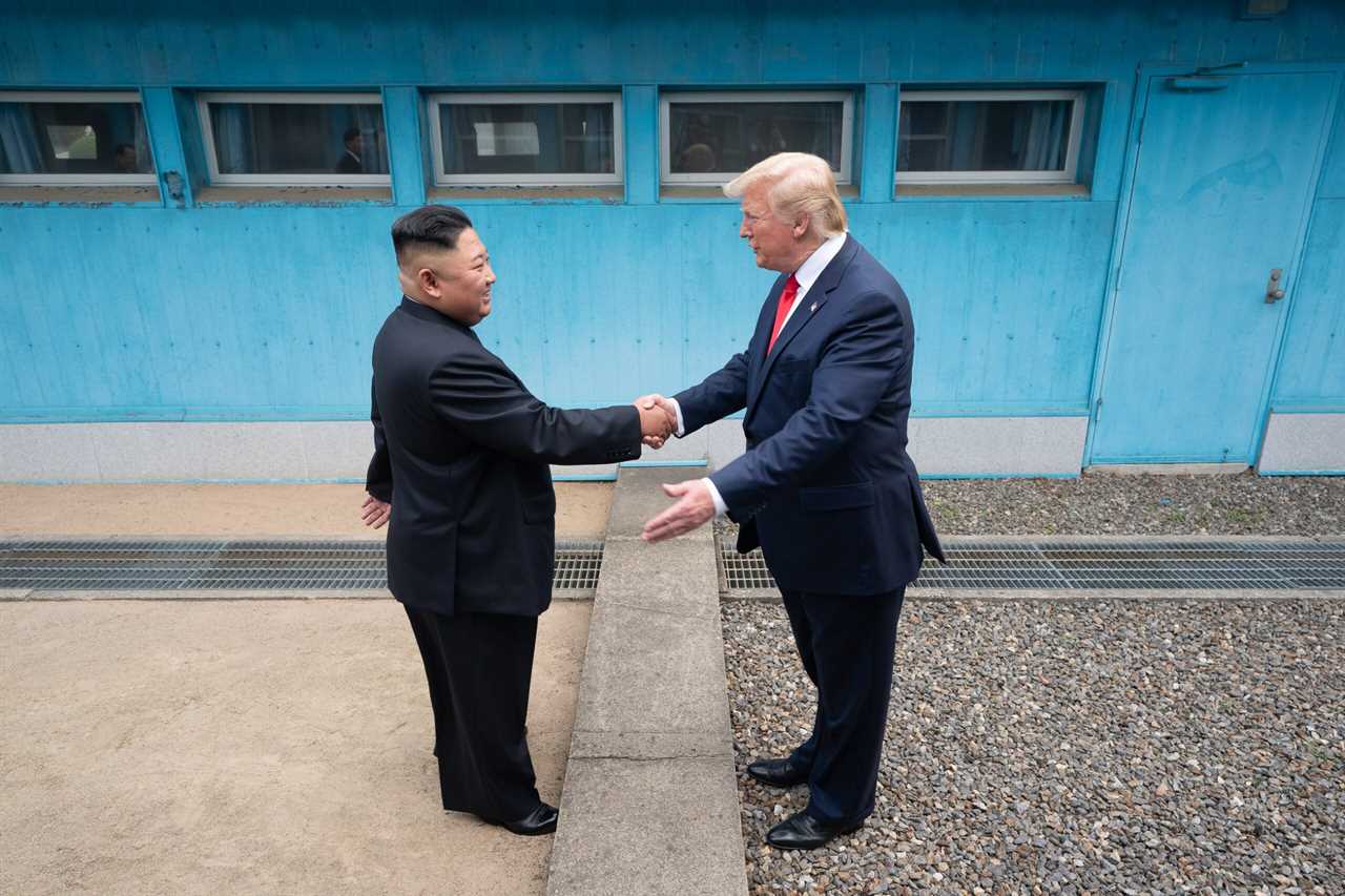 Kim Jong-un and Donald Trump shake hands during their historic meeting at the Korean Demilitarized Zone, symbolizing diplomatic efforts between North Korea and the United States.