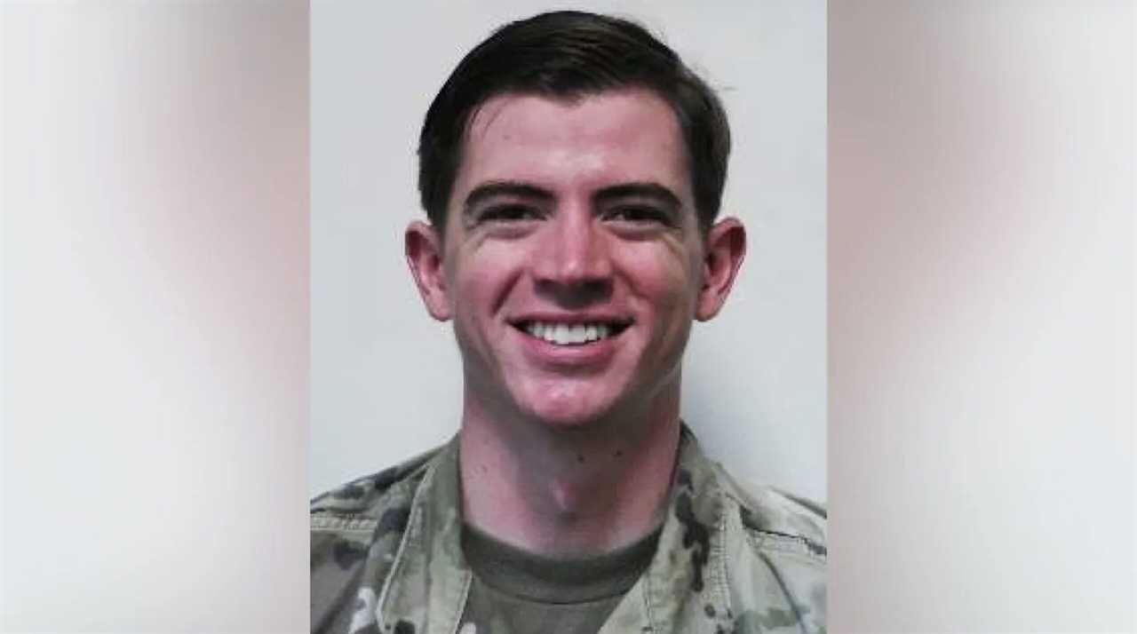 Smiling military personnel in uniform, posing against a neutral background, showcasing a friendly demeanor and professionalism.