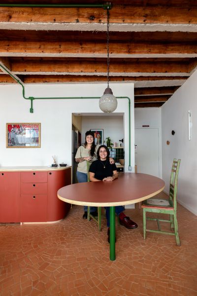 Amanda Nori and Stefany Guimarães hang out at the dining table in their São Paulo apartment.