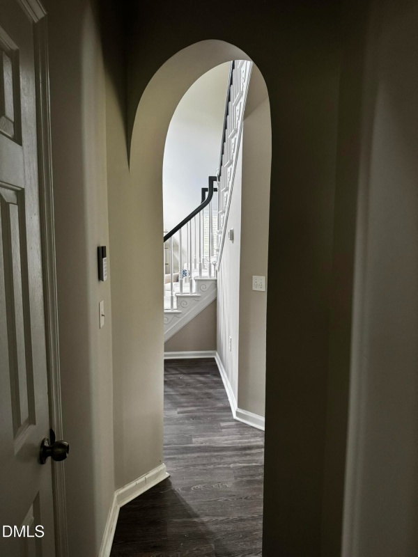 Arched hallway entrance leading to stairs.