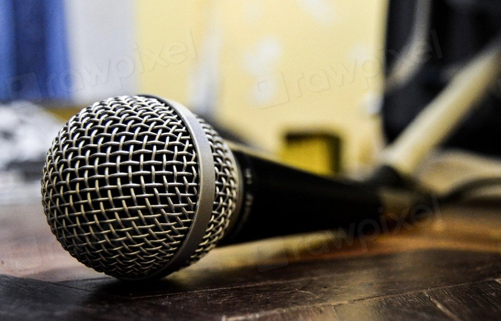 Close-up of a microphone resting on a wooden surface, ideal for music performances or recording sessions in a home studio setting.