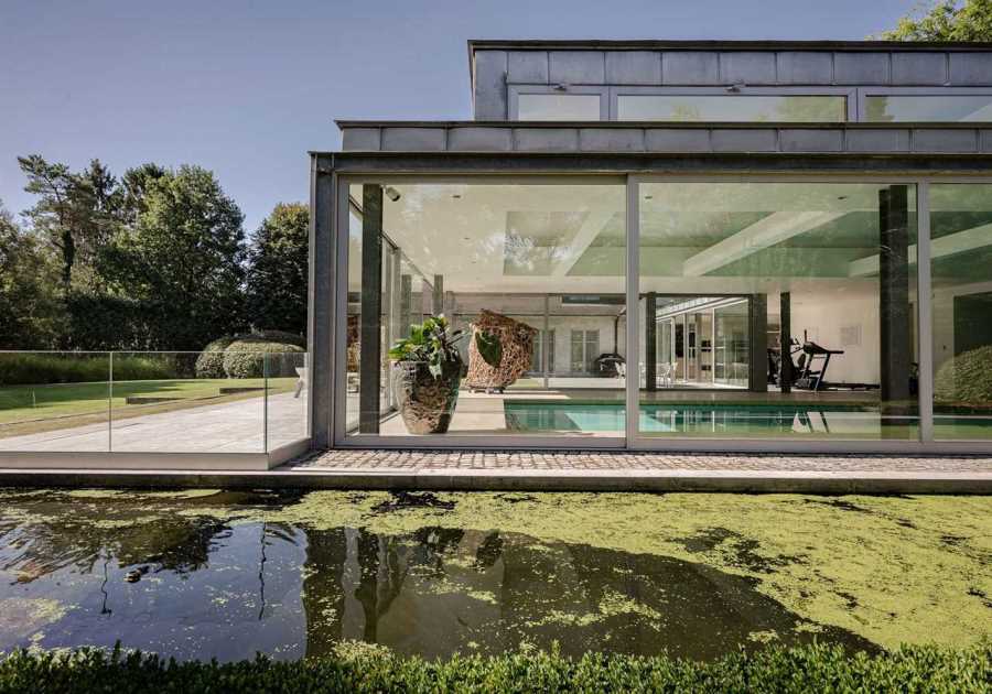 A  Contemporary Villa in Belgium Comes Complete With a Landscape Pond and Showroom Garage