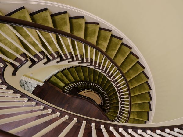 When Adrienne and Jonathan bought the Neo-Georgian-style home, the interiors featured a dark palette. They worked with interior designer Jason VanWarren, principal at Ellsworth Home, to lighten the spaces and bring back in or accentuate existing period details. The runner on the central staircase is from Crosby Street Studios.